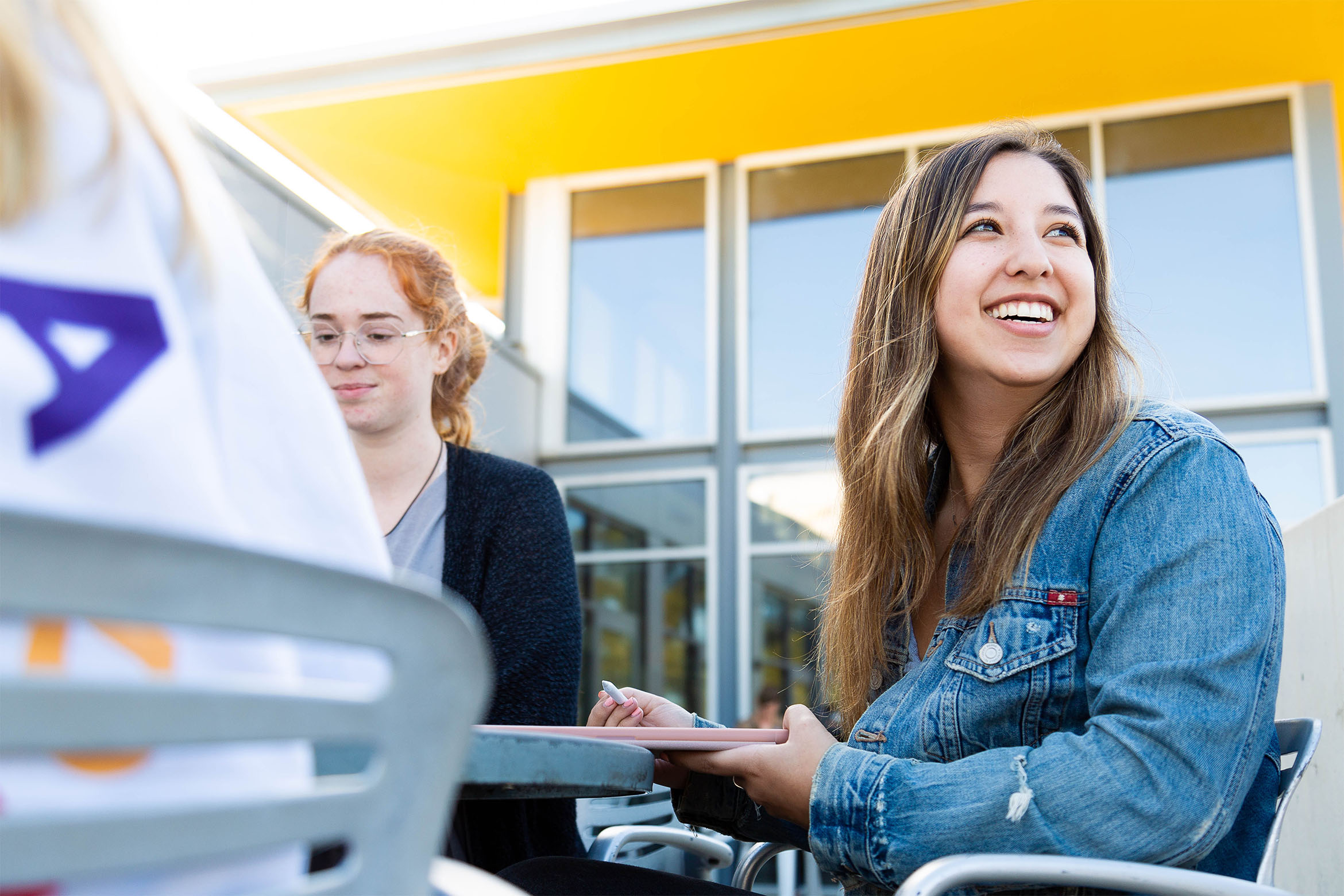 Students sitting outside of the Student Resources Building